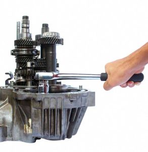 cropped-hand-holding-wrench-engine-agains